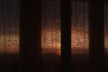 Window curtains in sunset light dark interior