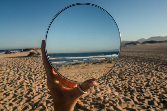 Conceptual photo of beautiful ocean coast with the sandy beach in the mirror reflection. Dream. Nature. Summer.