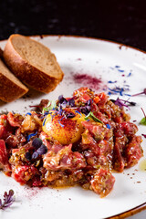 Raw beef meat tartar with sauce in plate