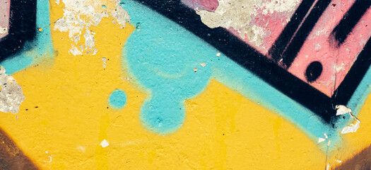 Detail of colorful graffiti wall. Old weathered colorful graffiti painted peeled plaster wall with falling off flakes of paint
