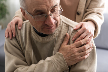 Hands of an elderly man holding the hand of a younger woman