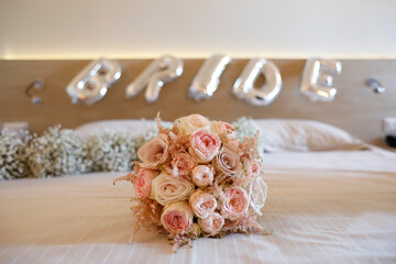 bellissimo bouquet di fiori poggiato su un letto e dietro la scritta 