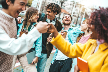 Happy multiracial friends having fun walking on city street - Group of different university...