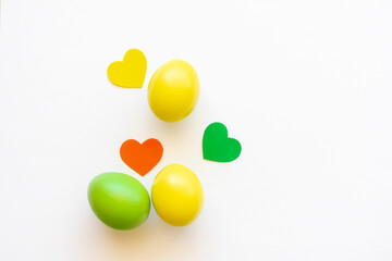 Easter eggs in yellow and green on a white background with hearts.