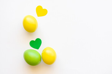 Easter eggs in yellow and green on a white background with hearts.