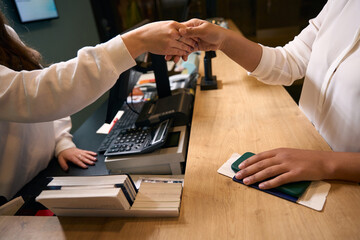 Friendly hotel receptionist greeting tourist before check-in