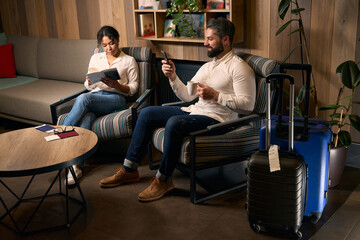 Travelers waiting for check-in in hotel foyer