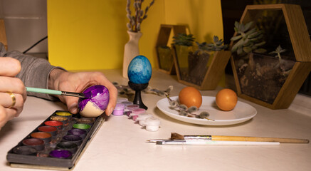 a man dyes eggs in different colors, close-up. The concept of preparation for the Easter holiday
