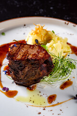 Grilled beef steak filet mignon with potato and sauce in plate