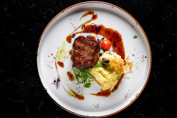 Grilled beef steak filet mignon with potato and sauce in plate