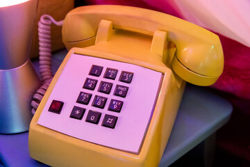 gros plan sur un téléphone jaune à boutons dans une ambiance rétro