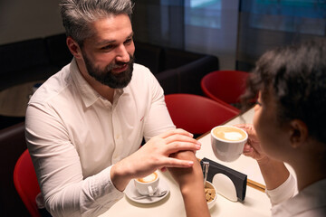 Romantic man and his female companion sitting in coffee shop
