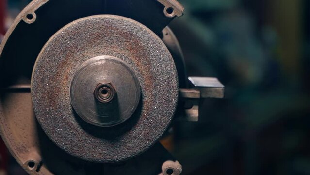 The abrasive disc of the grinder slowly rotates close-up, slow motion