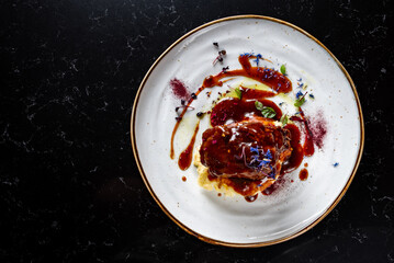 Stewed veal cheeks with mashed potatoes on plate