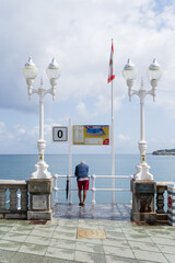 Obraz premium Una persona mira hacia el mar en el paseo marítimo de Gijón, España.