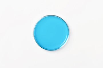 Petri dish with blue, blue liquid. On a white, light background. View from above.