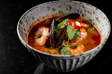 pan asian food. Tom Yam soup in bowl on table background