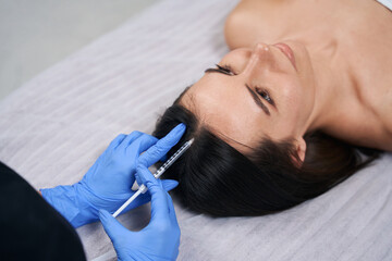 Female doing cosmetic procedures for face, hair nutrition