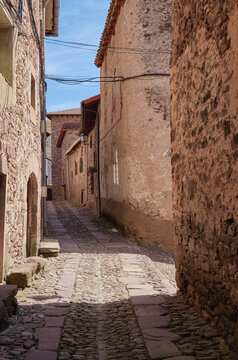 Fototapeta Cobblestone street in the middle of an ancient Spanish village