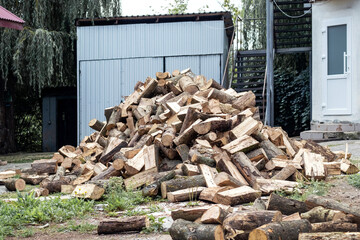 A pile of firewood for heating in winter in the yard of the farm