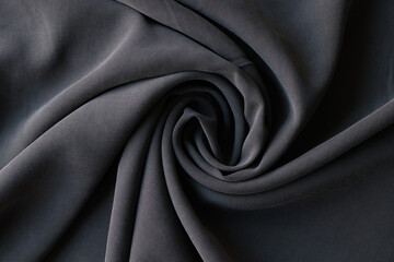 Rolled dark grey fabric sample in textile store or atelier