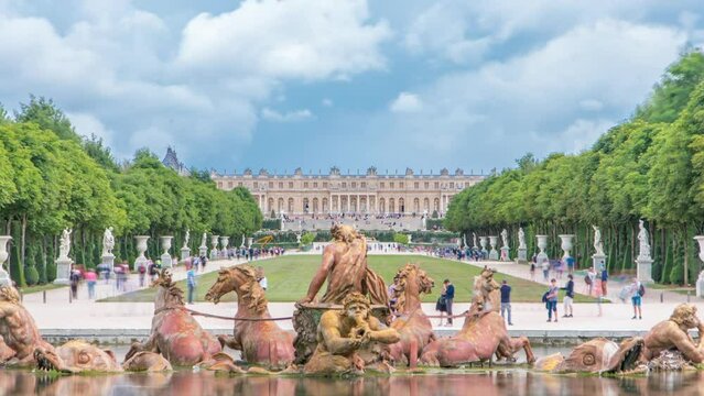 Apollo fountain in the Versailles Palace park with green lawn timelapse, Ile de France. Royal Palace on background with reflection on water. Crowd of tourists at summer day