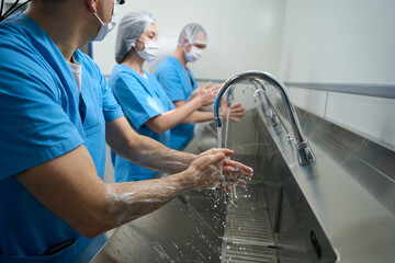 Men and women thoroughly wash their hands before the operation