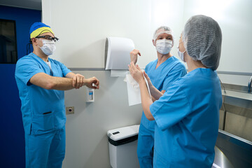 Medical staff treats hands with sanitizer before a surgical operation