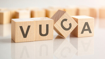 text VUCA on wooden blocks, background have blur effect