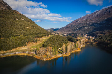 Panoramic aerial drone view on lake Toblino and mountains in sunny winter day. January 2023