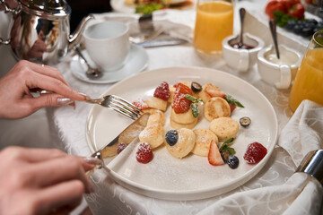Woman eats a light fruit salad with cutlery