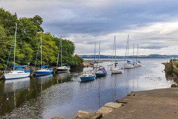 Fototapeta na wymiar Small boats and yachts moored at the mouth of the River Almond at Cramond near Edinburgh, Scotland.
