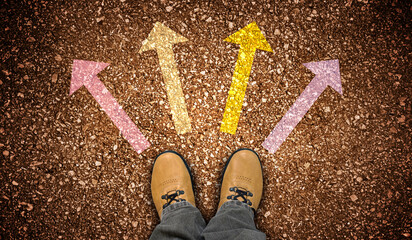 Yellow leather shoes and colorful four chalky arrows on ground - direction concept