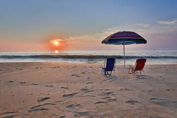 Beach umbrella and chairs on the beach at Sunrise