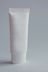Empty white plastic tube on a white background. Layout of cosmetic product branding. Space for copying. High quality photo