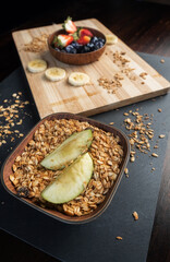 Close-up of apples, granola and other fruits for the preparation of a healthy snack.