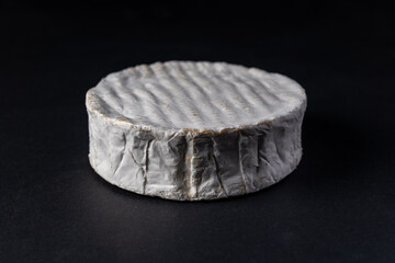 Camembert, French soft cheese isolated on black background