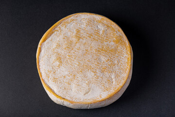 Reblochon French cheese isolated on a black background