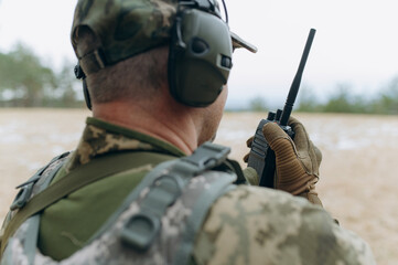 a soldier talks on a walkie-talkie. military in the forest. © Volodymyr
