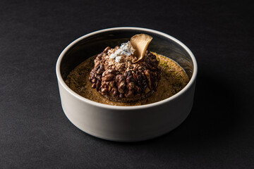 Gastronomic delights of restaurant dishes, crumble dessert with nuts isolated on a black background,culinary arts