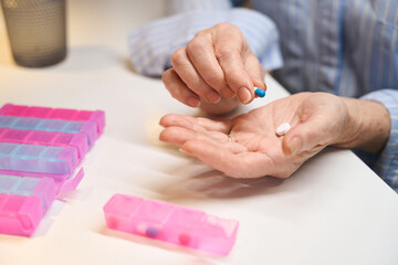 Elderly woman holds pills in her palms