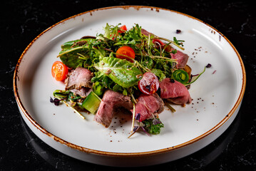 Roast beef salad with vegetables on plate
