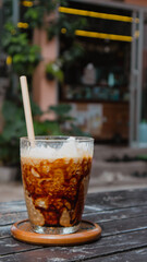 Closeup of iced coconut caramel latte coffee drink with paper straw at a tropical café