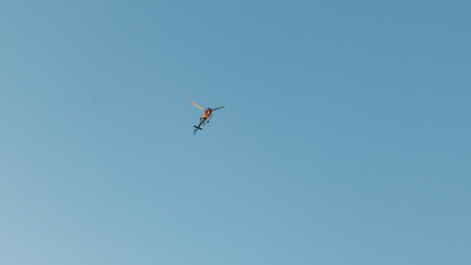 Helicopter up in the air, dusty blue background with copy space