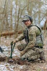 Fototapeta premium A soldier digs the ground in position. Preparation for the attack. Digging a trench.