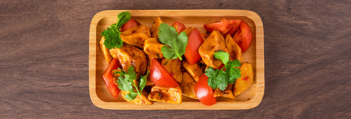 Baked potato wedges on wooden table