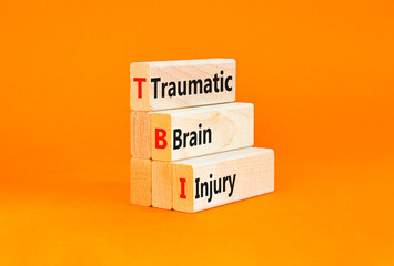TBI traumatic brain injury symbol. Concept words TBI traumatic brain injury on wooden blocks on a beautiful orange table orange background. Medical and TBI traumatic brain injury concept. Copy space.
