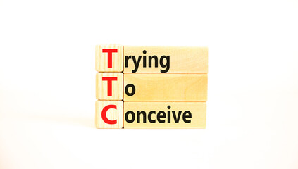 TTC trying to conceive symbol. Concept words TTC trying to conceive on wooden blocks on a beautiful white table white background. Medical and TTC trying to conceive concept. Copy space.