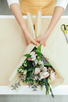 Florist making a bouquet of beautiful blooming eustomas