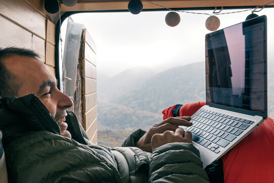 Joyful man browsing internet on his laptop